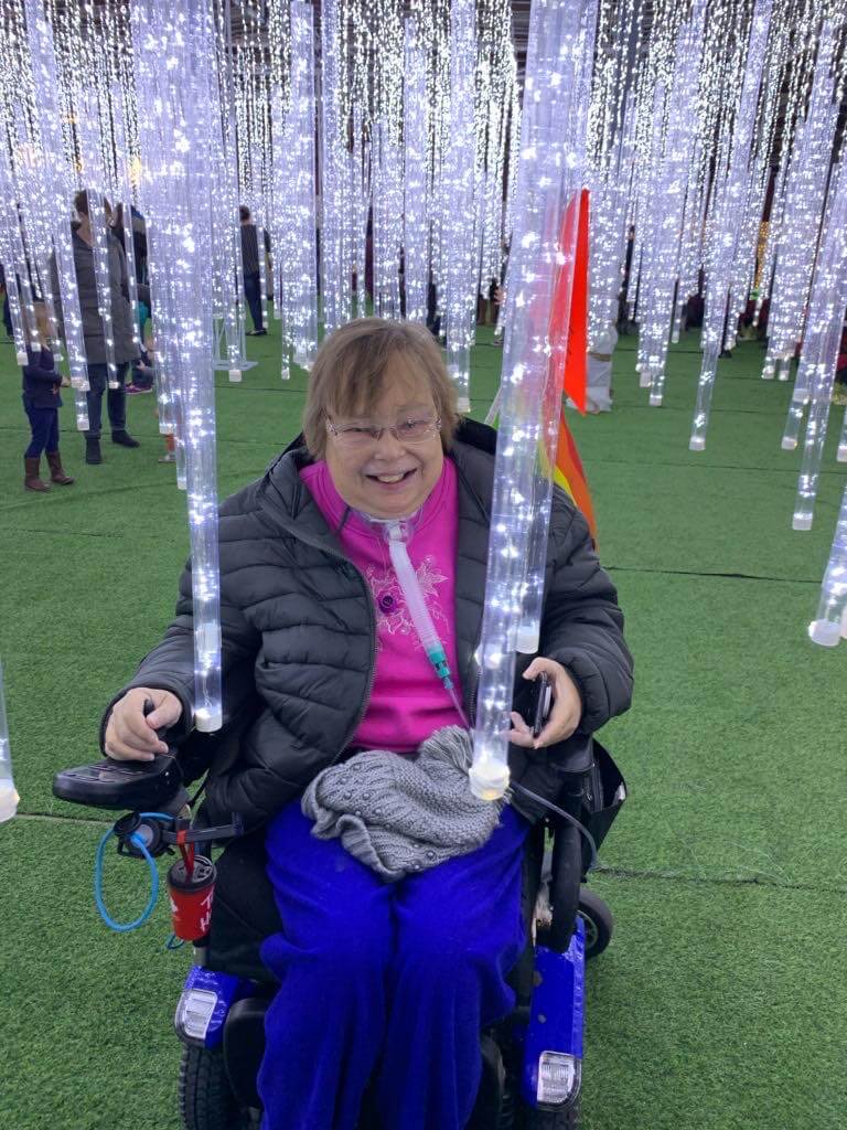 Senior woman in wheelchair in icicle forest at Glow Park